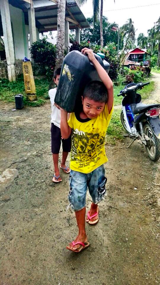 School Boy Carrying Water for Family