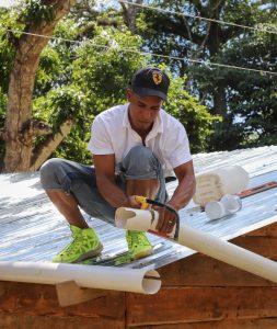 Man holding pipe squatting on a rooftop