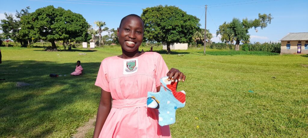 A student at Alem Primary School shows off the reusable pad she made